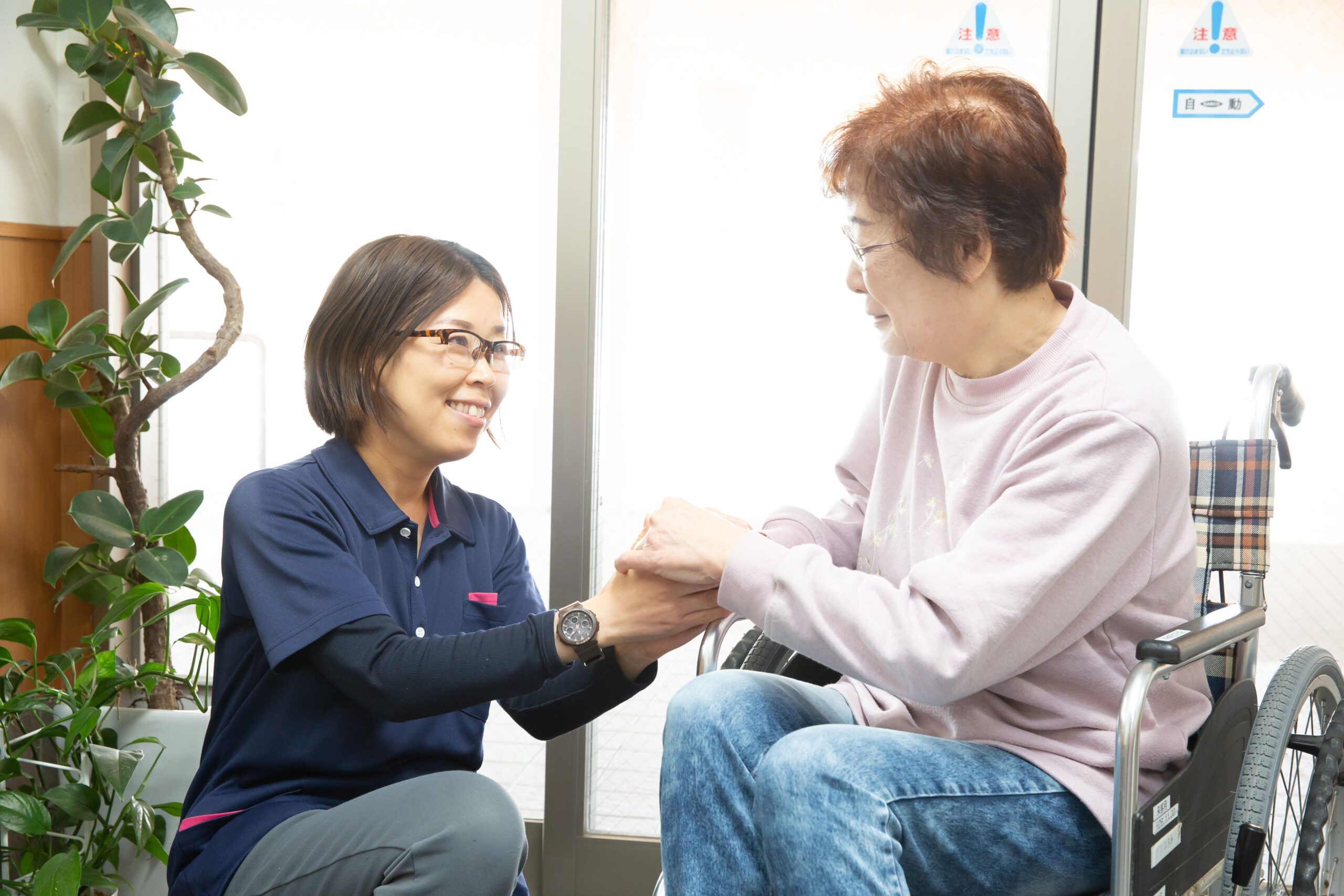 車椅子の女性と介護職員の写真